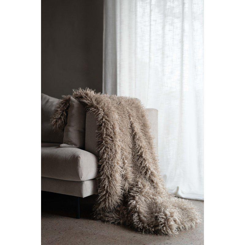 Curly pläd sand 120x150 cm draperad över beige soffa